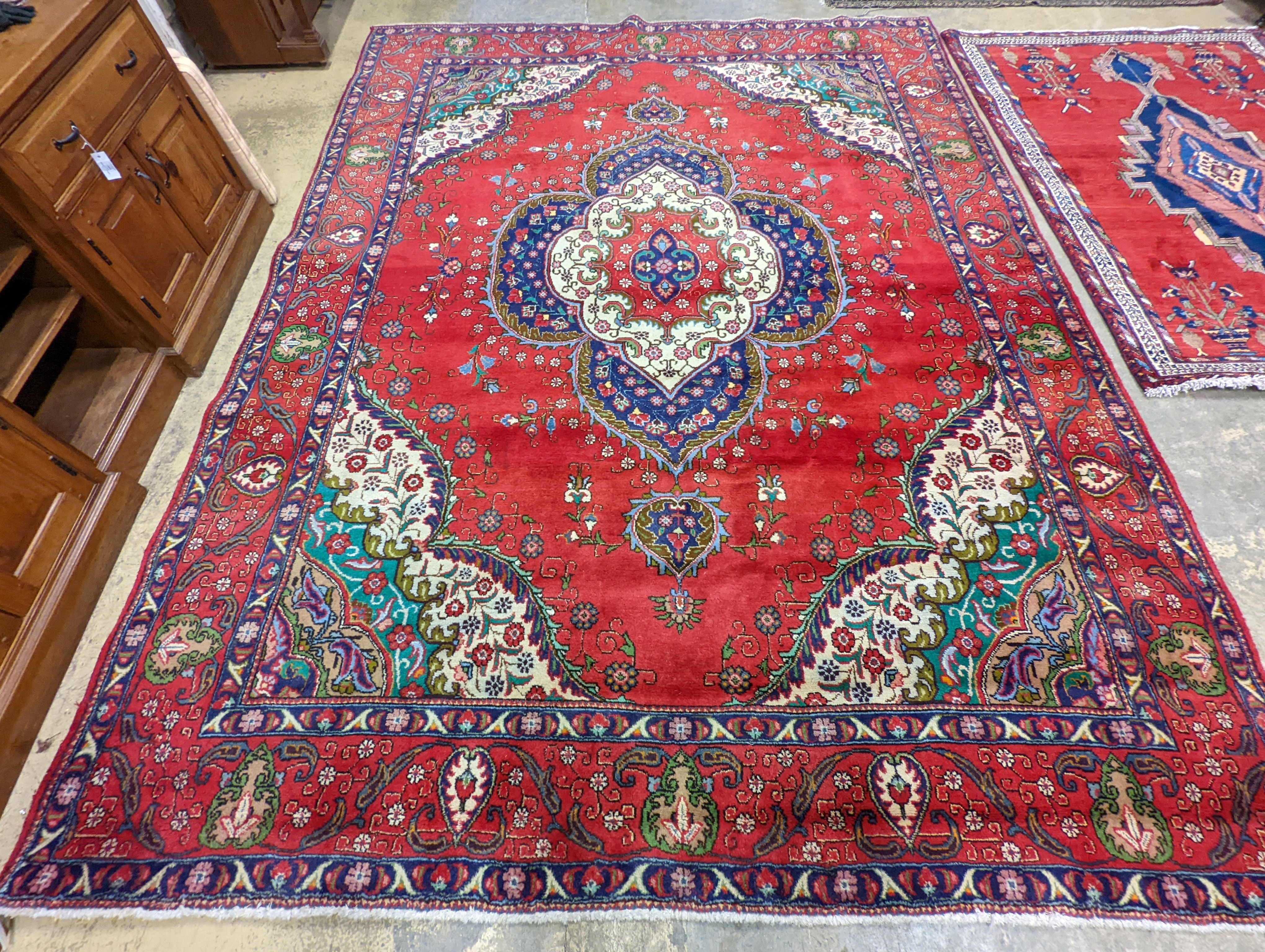 A Tabriz red ground carpet, 380 x 300cm